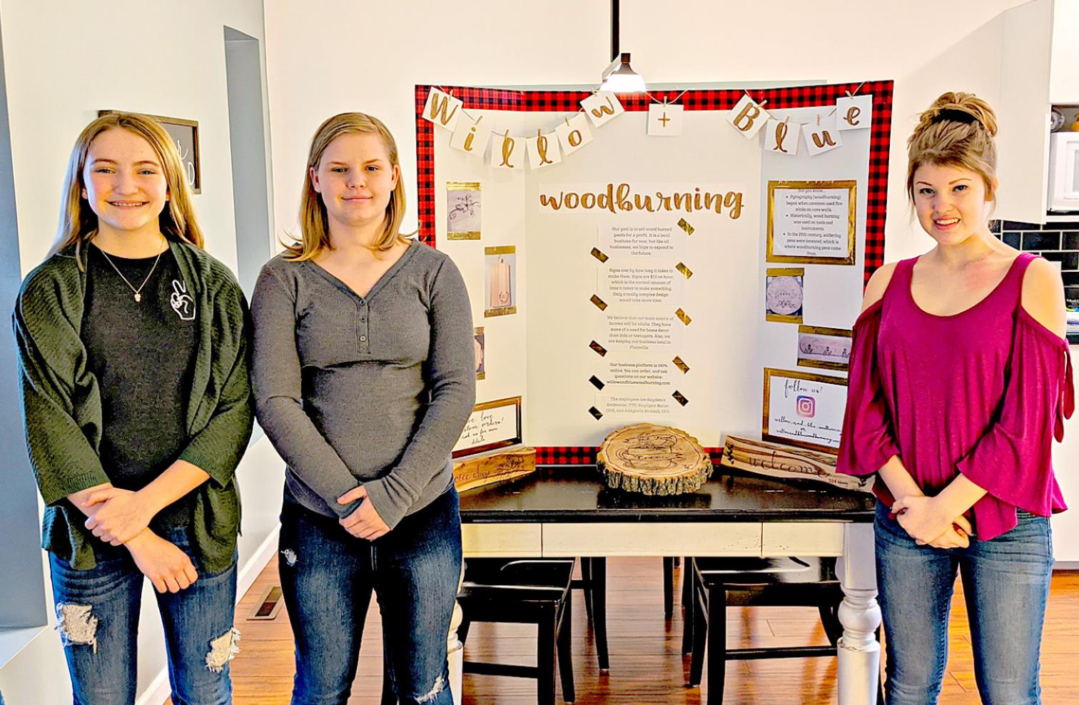 KAYDENCE GREBOWIEC, Addybelle Birdsall and Kaytlynn Butler of Plainville Junior High, are pictured with their display, Willow &amp; Blue Woodburning during the Rooks County Youth Entrepreneurship Challenge held recently.