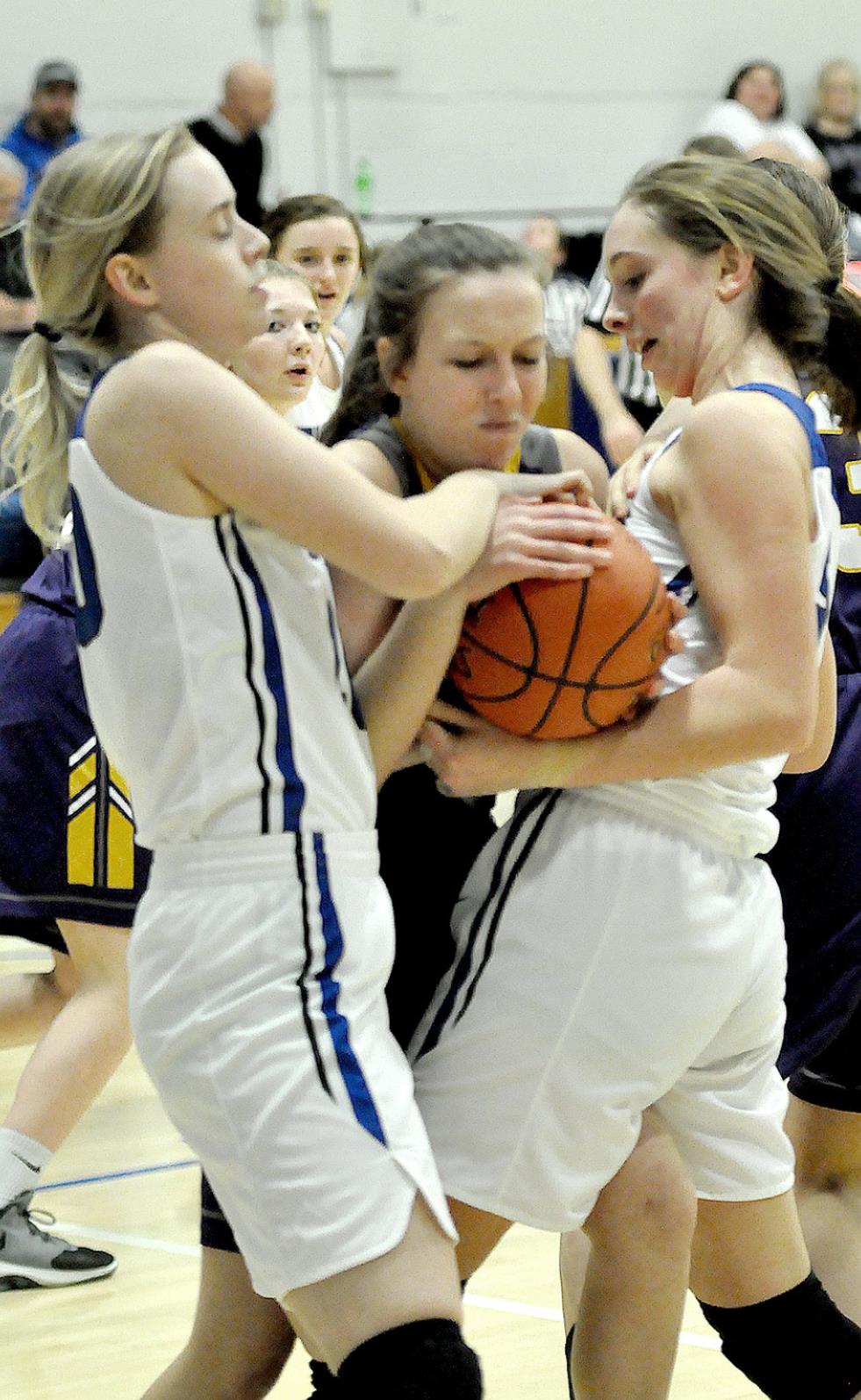 ELLIE BELLERIVE (left) and Olivia Dix (right) tie up their Trego Lady Eagle opponent during action last Tuesday at Tiger Gymnasium.