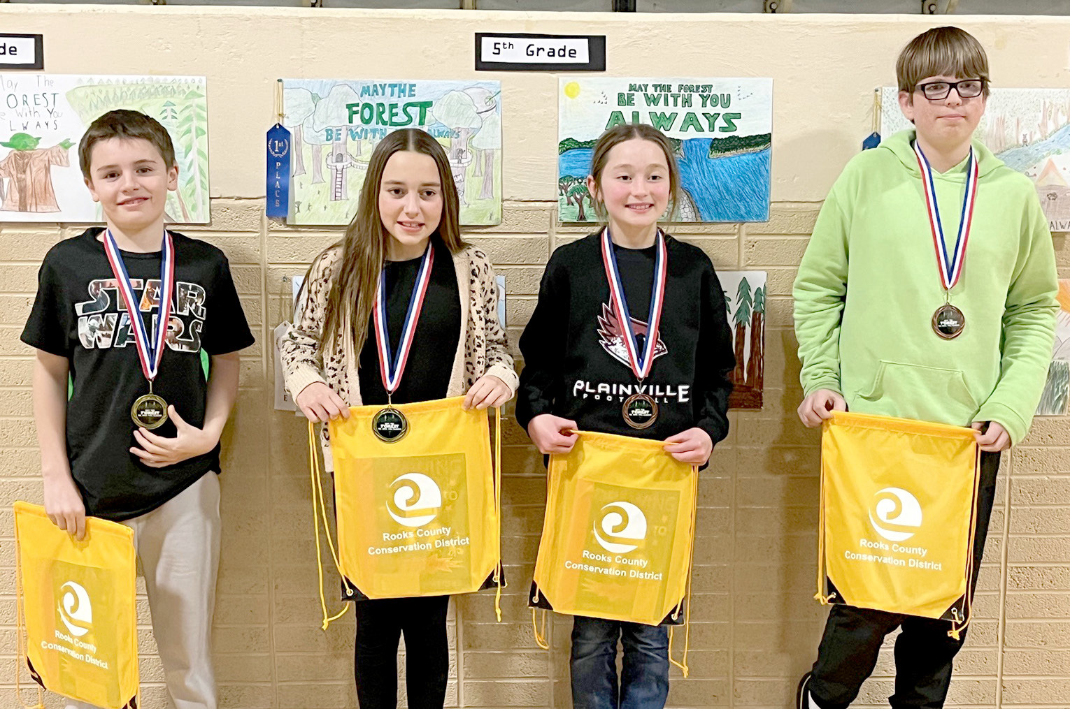 FIFTH-GRADE POSTER WINNERS (l to r)—1st, Brogan Pfaff, Plainville; 2nd, Kaylyn Becker, Sacred Heart; 3rd, Leilah Slaubaugh, Sacred Heart; and 4th, Vernon Waters, Stockton.