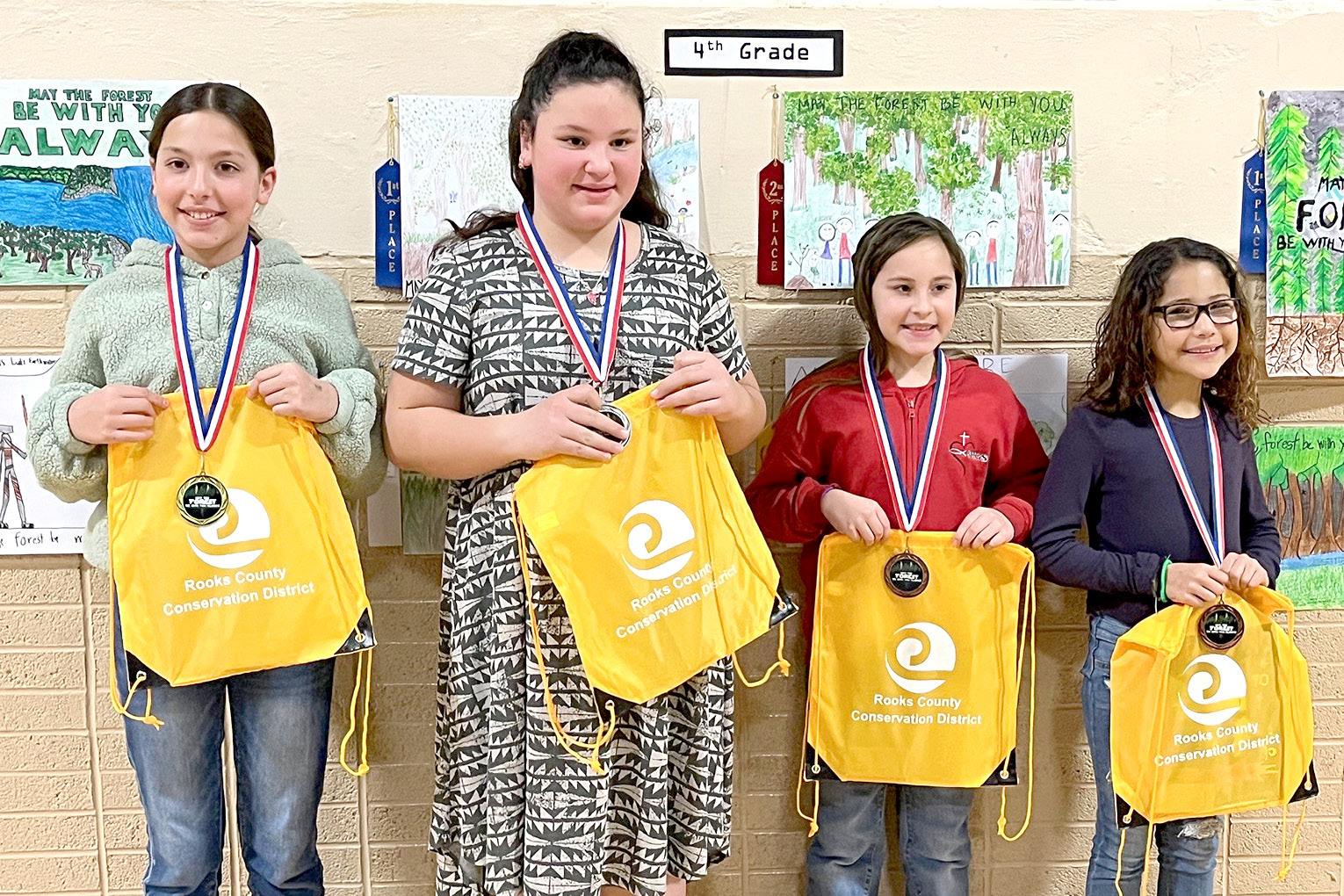 FOURTH-GRADE POSTER WINNERS (l to r)—1st, Hannah Gosselin, Damar; 2nd, Anabell Reilly, Damar; 3rd, Anabella Hrabe, Sacred Heart; and 4th, Addie Johnston, Stockton.