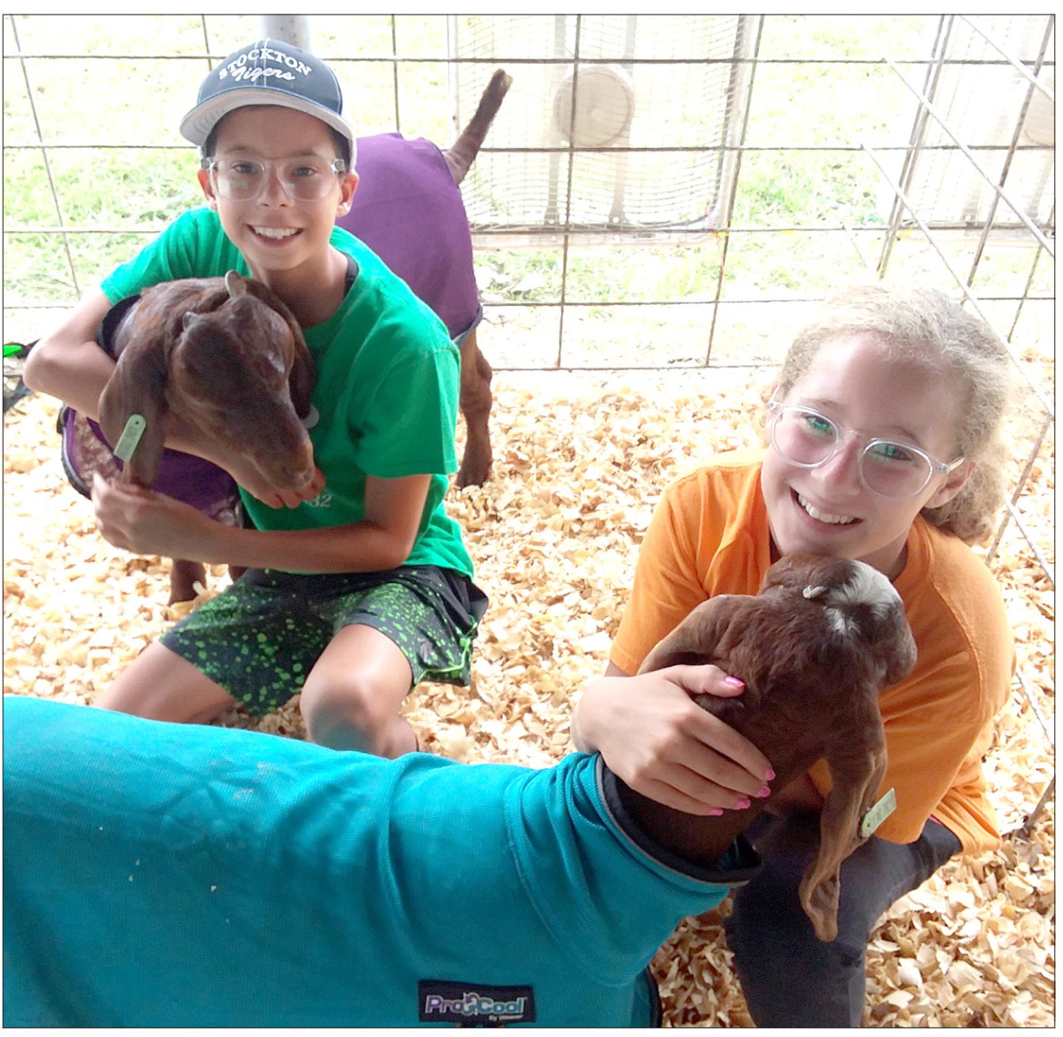 CAROLINA (LEFT) AND TEMPRANCE (RIGHT) NORTHUP show off their goats Biscuit and Gillmore at this year’s Rooks County 4-H Fair. They are members of Star 4-H.