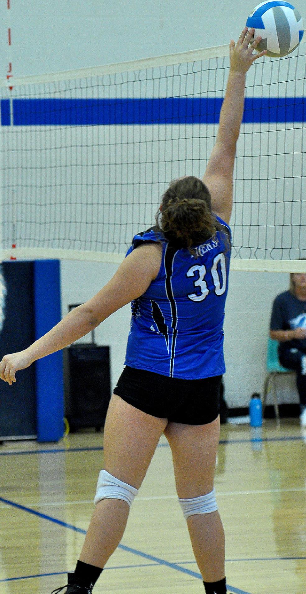 CAYDANCE CARTER tips the ball over the net during junior high action against Lucas/Sylvan.