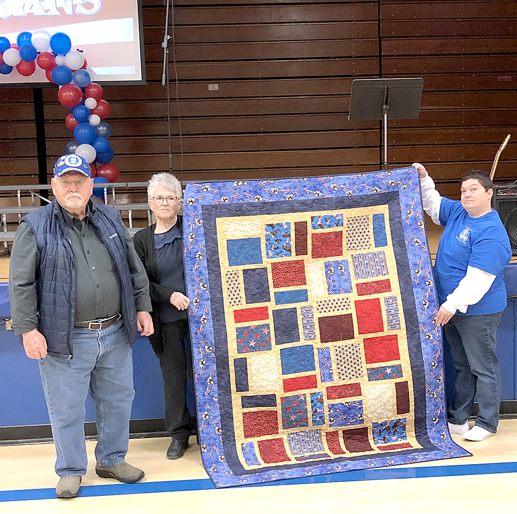 ROLAND JOHNSTON (Air Force) is pictured receiving his Quilt of Valor from Diane Maddy and Dena Bouchey at the Veterans Day program, “A Salute To Our Veterans” held on Friday, November 11th at Stockton High School.