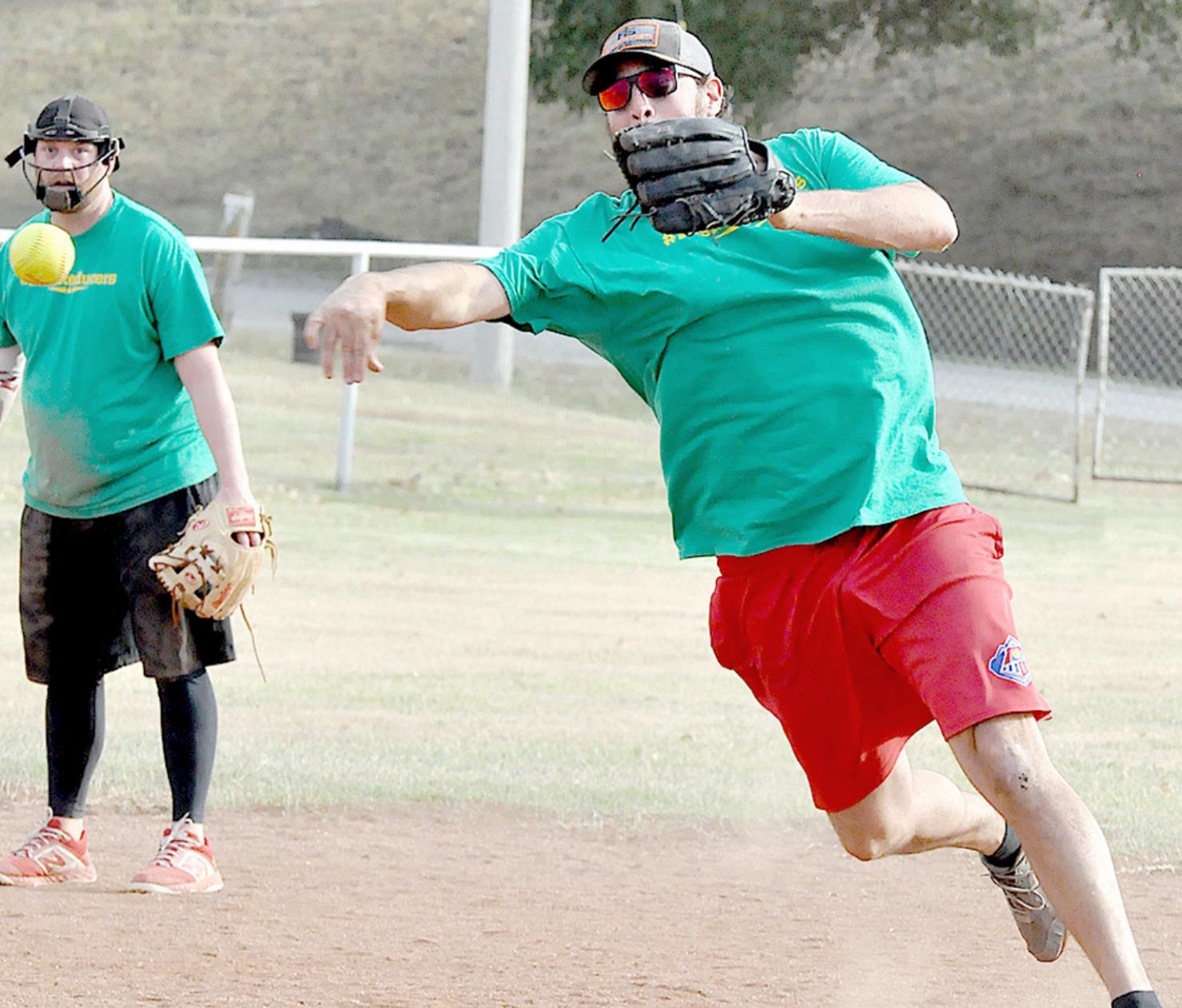 CHRIS PULEC, who resides in Pine, Colo., fires the ball to first base, while Jeremy Robinson, Newton, looks on. The action took place at the softball tournament held on Saturday at Kincaid Field.
