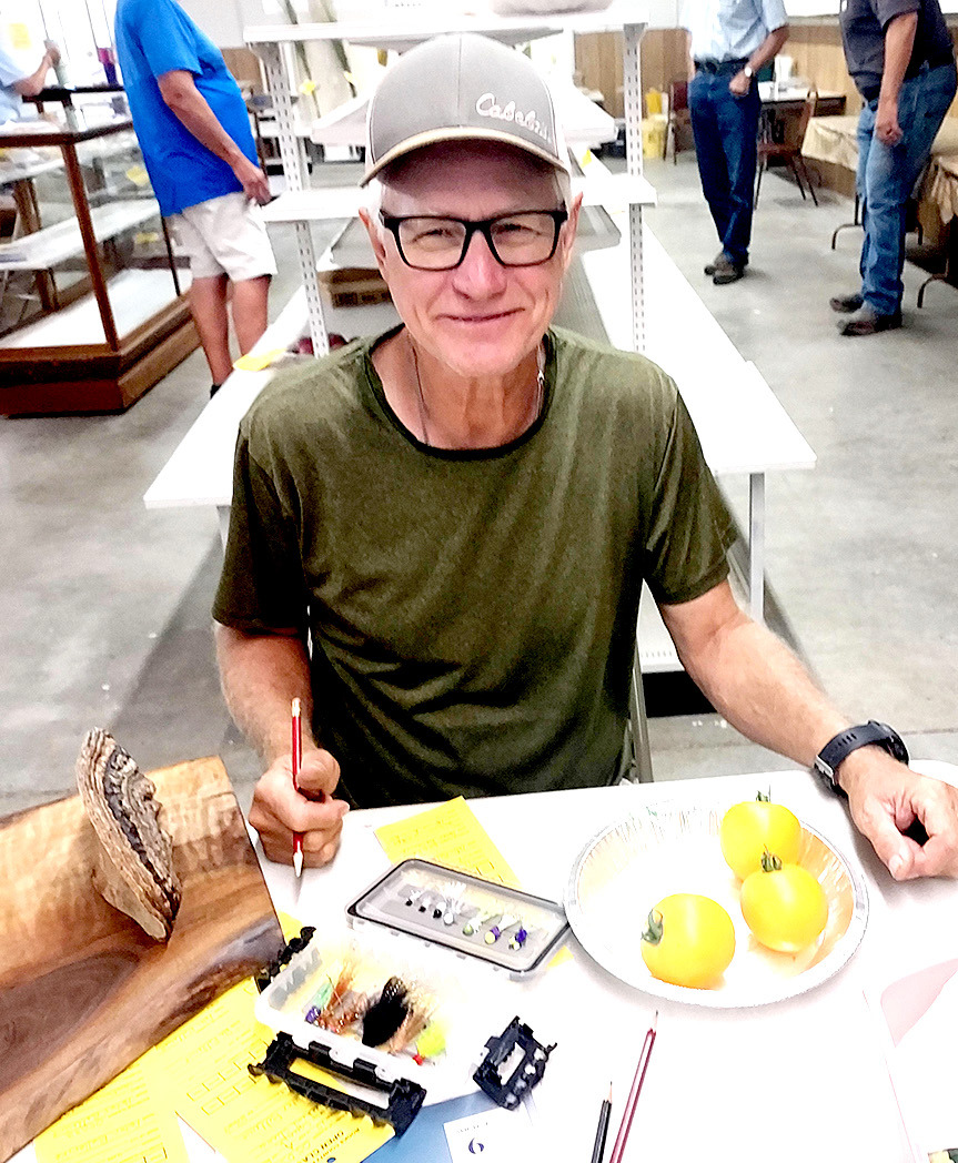PETE BELLERIVE registers his fishing flies and Lemon Boy tomatoes in the Open Class Category at this year’s Fair.