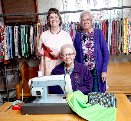 THE LADIES quilting this past Monday were (from left) Karen Reed, Barb Record (sitting), and Barb Williams. The ladies quilt every Monday morning in the St. Thomas Church basement, cutting, sewing, and tying their way into Heaven “one piece of fabric at a time.”