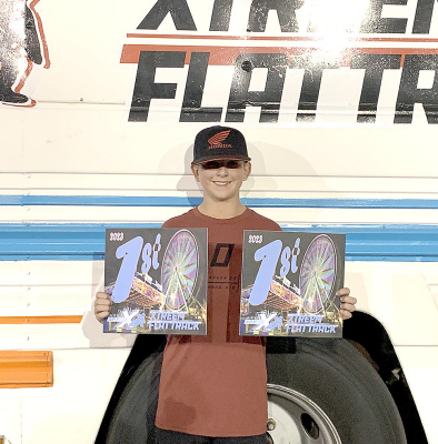HUNTER TOWNLEY poses with two of his trophies he has won this racing season. Townley has come in under the checkered flag a few times this summer and is making a name for himself in the world of flat track motorcycle racing.