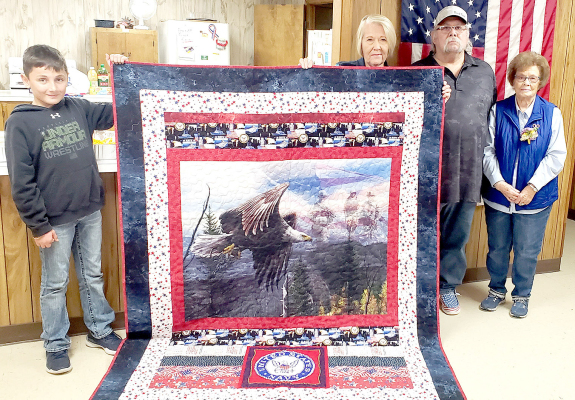 ON SATURDAY, DECEMBER 3RD AT THE WALKER SENIOR CENTER, VFW Auxiliary President Deb Niermeier presented Lawrence “Bub” Cadoret with a Quilt of Valor made for him by Janie Lowry. Cadoret served six years in the United States Navy with half of that time spent in the Mediterranean. Pictured are (from left): Blake Rothe, Janie Lowry, Bub Cadoret and his mother, Betty Cadoret. (Courtesy Photo)