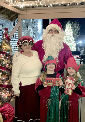 SANTA AND MRS. CLAUS (Jason and Rebecca Creighton) were fortunate to have the reliable help of their elves, Emery and Finley Peterson during Olde Tyme Christmas.