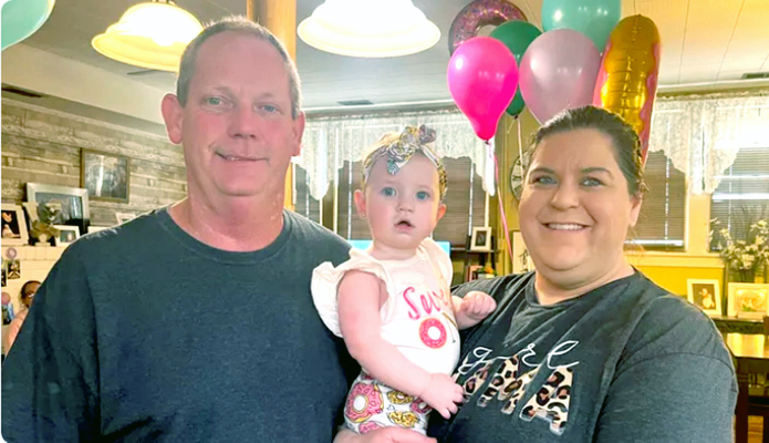 CHARLES VELZ, left, enjoying a happy time with his wife, Leah, right, and their one-year-old daughter, Lainey, center.