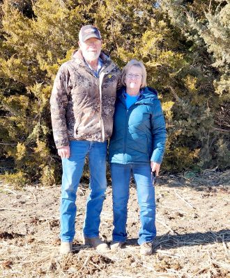 VERNON & DIANE STRUTT of rural Woodston have been named the 2022 Windbreak Award Winner. They are pictured next to the windbreak planted in 2006 with the help of their family. The windbreak consists of Eastern Red Cedars.