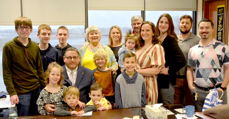 JOINING NIENSTEDT AT HIS RETIREMENT RECEPTION on Friday, March 31, his last day as Ottawa City Manager, include back row, from left: Lucas Shephard, Jack Nienstedt, Grant Nienstedt, Rita Nienstedt, Kim Nienstedt, Marshall Nienstedt, Robyn Whitaker (holding Hannah Dickson), Aimee Nienstedt Dickson, Dalton Whitaker, and Jason Dickson. Middle row, from left: Sutton Whitaker, Richard Nienstedt, Wells Whitaker, and Jonah Dickson; in front, from left: Hoyt Whitaker, and Beau Nienstedt. Richard served as Stockton’