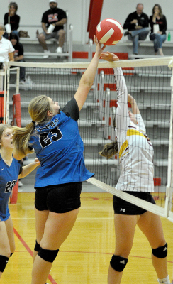 BRIN MUIR tips the ball over the net in the Lady Tigers’ win against Osborne at the Hill City Triangular on October 4. Teammate Liz Busonic is also pictured.