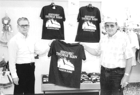 Ken Bates of Bates of Stockton presented a t-shirt to Laurence Hull of Woodston, president of Thomas Barn, Inc. A donation from the sale of each shirt went to refurbishing the Thomas Big Barn which was located northwest of Woodston. (The William Thomas Barn was 100 feet long, 64 feet wide and 64 feet tall. It could stable 54 horses and 50 head of cattle. It won the 1908 State Board of Agriculture photography contest for 'Best Barn' in Kansas. Reverend Richard Taylor had formed a not-for-profit corporation f