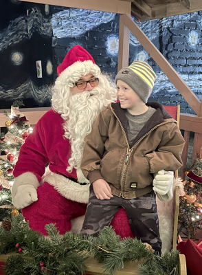 BLAKE BALTHAZOR was all smiles as he tried to convince Santa he had been a good boy this year. Santa, Mrs. Claus and the elves were kept very busy the night of Olde Tyme Christmas listening to the wish lists of all the children.