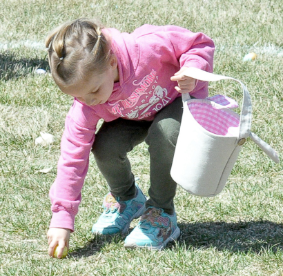 ALENA RIFFEL finds another egg to add to her basket during the Sigma Phi ESA Easter Egg Hunt held last Saturday afternoon in the park. Many braved the windy conditions for a chance to enjoy the annual event.