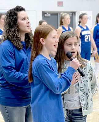 OMREE DIBBLE & HARPER LOWRY singing the National Athem at a home basketball game with music instructor Megan Reiner.