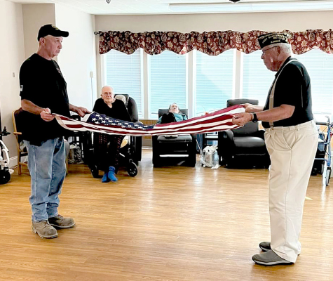 VETERANS ED THAYER AND JOHN BERKLEY show how to fold the flag at the presentation held at the Solomon Valley Manor on Flag Day, June 14th. (Courtesy Photo)