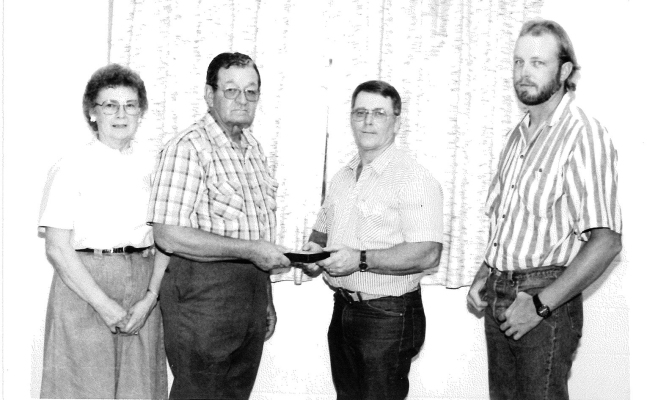 VIC JACOBS, STOCKTON CITY’S HEAD ELECTRICIAN, was honored at a Retirement Meal at the American Legion Hall in August 1991. A good crowd of City and former City employees were on hand to wish Vic well. The picture from left shows Vic’s wife, Betty, Vic, Gorman Rubottom, who is presenting Vic with a gold pocket watch, and Vic and Betty’s son, Jon, who was taking over his father’s duties with the City.