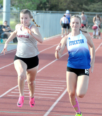 STOCKTON SOPHOMORE AVA DIX (right) races Zoe Brown of Plainvlle to the finish line to capture third place in the 100 Meter Dash at the 2023 Mid-Continent League Track Meet held in Phillipsburg last Friday. Dix ran the race in 13.58, while Brown was fourth with a time of 13.63.