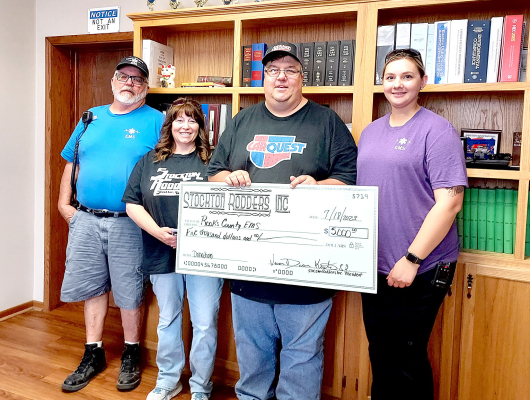 THE STOCKTON RODDERS presented the Rooks County EMS with a donation check in the amount of $5,000.00 at the Stockton City Commission meeting on Tuesday, July 18th. Pictured accepting the donation from Stockton Rodders Libby and Dean Kester (middle) were EMT Jim Prockish (left) and Rooks County EMS Director Megan Niblock (right).