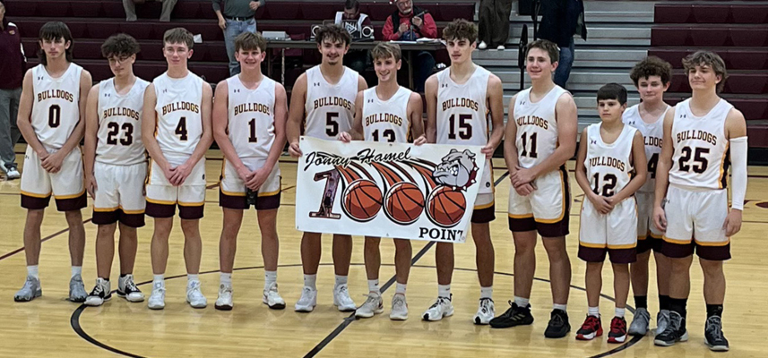 OSBORNE HIGH SCHOOL SENIOR JONNY HAMEL (center) was recognized on Tuesday, December 12, when the Bulldogs hosted Victoria, for reaching 1,000 points in his high school career. He actually accomplished this milestone during the Osborne vs. Hodgeman County game of the Purple and Gold Basketball Tournament held the week prior in WaKeeney. Hamel is the son of Scott and Christina Hamel, Stockton. Congratulations, Jonny!