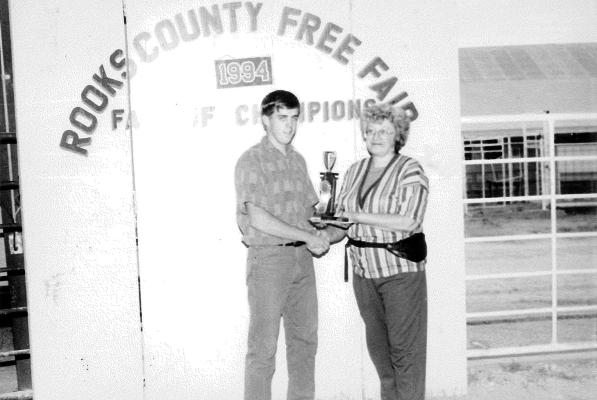 GRAND CHAMPION FITTING AND SHOWING CHAMPION SENIOR DIVISION at the 1994 Rooks County Free Fair was Randy Odle of Mt. Pleasant 4-H. He is pictured with sponsor Twila Sander of Prime Time Video.