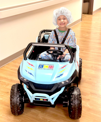 DAXSYN CLARIDGE, son of RCH surgical RN Amanda Claridge, showcases the hospital's new vehicle to transport pediatric patients to surgical and radiology procedures. The customized decals were made by Amanda.