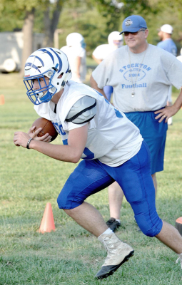 SHS SENIOR JACE HULL runs the ball in a drill during practice last week, while head coach Phil Conyac looks on.