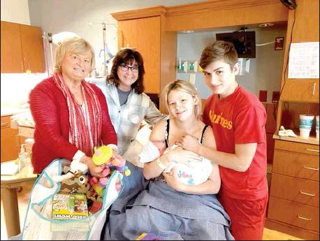 DIANE MCREYNOLDS, RCHA president (far left), and Kathy Ramsay, RCHA member, congratulate Shyanne, Trey, and baby Triton as he was the first baby born in 2020 at RCH.